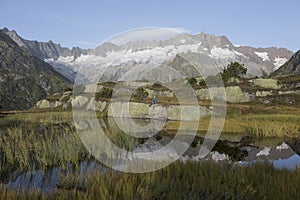 Alpinist makes a break during a sunrise at a mountain lake in the alps