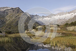 Alpinist makes a break during a sunrise at a mountain lake in the alps