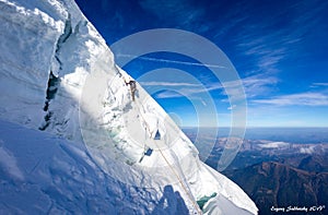 Alpinist mountaineer climbing dangerous ice crevasse crack