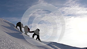 Alpinist move their hands to each other to help a friend climb to the top of a snowy mountain. teamwork desire to win
