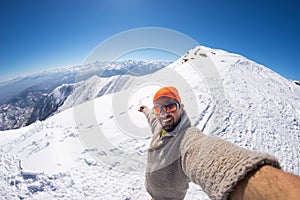Alpinist taking selfie on snowcapped mountain, fisheye lens