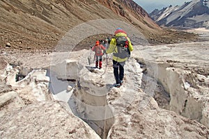 Alpinists mountaineers climbing over ice snow crevasse crack