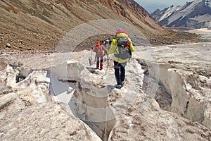 Alpinists mountaineers climbing over ice snow crevasse crack photo