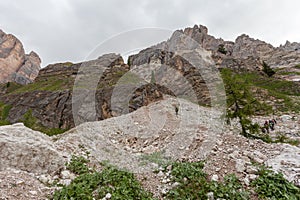 Alpinists over a debris flow at the foot of Dibona section, an important geologic site of Tofana Mountain Group