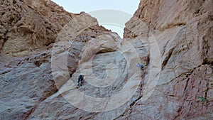 Alpinists in protective equipment climb mountain