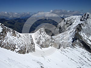 The Alps - aerial view of mountain peaks with snow in clouds