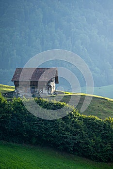 Alps house in mountains. Mountain green field alpine Mountains landscape nature with wooden old houses. Travel and