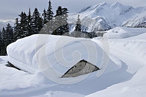 Alpi cottage coperto secondo la neve 