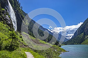 Alps mountains with blue lake and waterfall. Photo taked at Stillup Lake, Austria, Tyrol