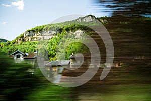 Alps mountains and hidden house seen from fast train in motion