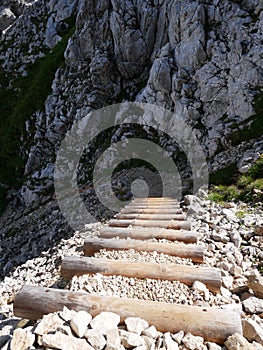 Alpspitze hiking track - walking downhill on natural wooden rocky mountains stairs in bavarian Alps