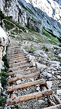 Alpspitze hiking track - walking downhill on natural wooden rocky mountains stairs in bavarian Alps