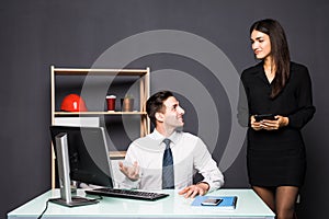 We already have great results. Young beautiful woman pointing at laptop with smile and discussing something with her coworker whil