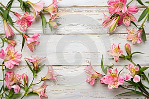 Alstroemeria flowers border on a white wooden table in a flat lay composition