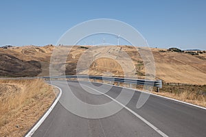 Alta Irpienia, windy hills in full sun. Summer, wheat fields, asphalt ribbon curving towards the sky. Italy, Campania