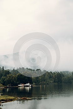 Altai nature at dawn in the fog. Haze in the forest and on the lake, atmospheric weather for the screensaver.