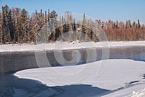 Altai river Biya in winter season. Banks of river are covered by ice and snow