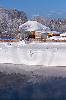 Altai russian country village Talitsa under winter snow on bank of river