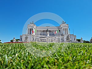 Altar of the fatherland, a famous Italian national monument. Green lawn in front, seen from Piazza Venezia