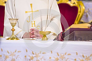 Altar with missal and host which becomes the body of Christ and chalice to receive the wine, the blood of Christ