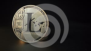 Altcoin Litecoin cryptocurrency gold coin. Gold coin with blockchain symbols. Black background. Macro detail shot