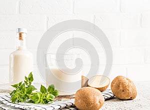 Alterative potato vegetable milk. glass bottles against a white brick wall. the concept of a healthy vegetarian diet