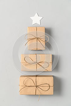 Alternative Christmas tree made from gift boxes with a red star on a light gray background.