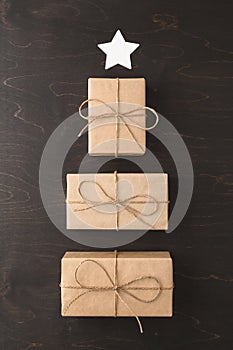 Alternative Christmas tree made from gift boxes with a white star on a dark brown background.
