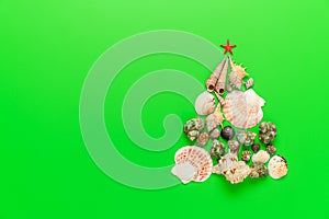 Alternative Christmas tree made from seashells and with a red starfish on a green background.