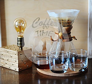 Alternative coffee brewing in the filter. Glass beakers. Table lamp with Edison bulb