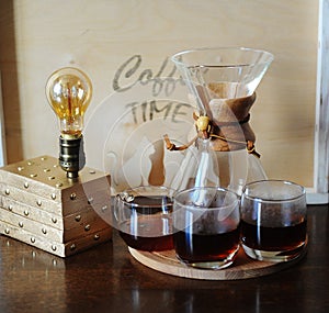 Alternative coffee brewing in the filter. Glass beakers. Table lamp with Edison bulb