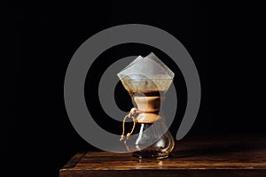 Alternative coffee in chemex with filter cone on wooden table photo