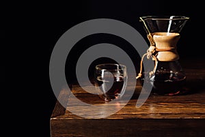 alternative coffee in chemex and glass mug on wooden table photo