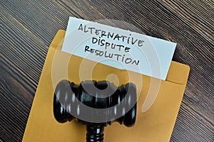 Alternative Dispute Resolution text on document with gavel above brown envelope