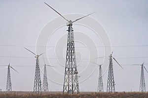 Alternative energy shot of wind turbine farm during foggy morning