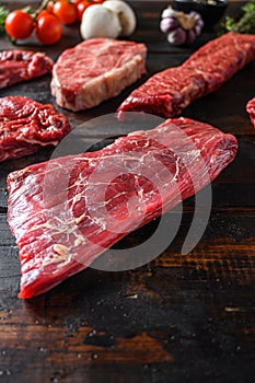 Alternative Flank bavette or flap steak beef t steak near tri-tip and top blade oyster cuts close up in front of other cuts in