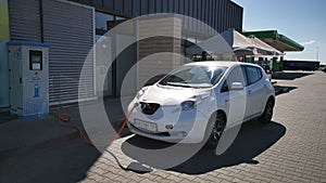 Alternative fuel concept. Refueling electric car Nissan Leaf on WOG Gas station. Network of charging stations on Kiev