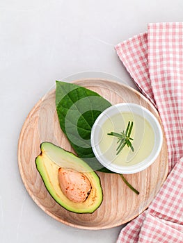 Alternative health care fresh avocado , leaves and oil on marbl