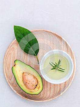 Alternative health care fresh avocado , leaves and oil on marbl