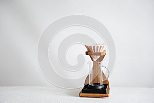 Alternative manual coffee brewing. Pink ceramic origami dripper. Wooden stand. Light background. Free space for text