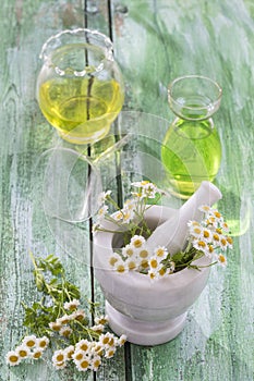 Alternative Medicine. chamomille, in a marble mortar. Essential oils and herbal supplements.