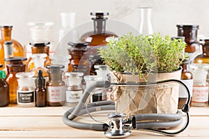 Alternative medicine concept medicine in bottles, medicinal herbs and stethoscope on a wooden table