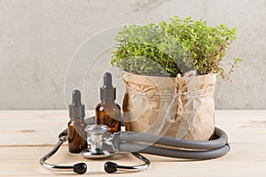 Alternative medicine concept medicine in bottles, medicinal herbs and stethoscope on a wooden table