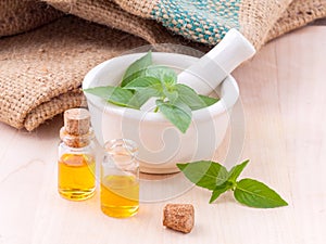 Alternative medicine lemon basil oil natural spas ingredients for aroma aromatherapy with mortar on wooden background.