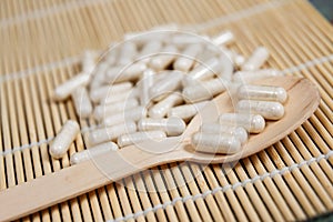 Alternative medicine tablets on a wooden spoon