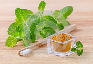 Alternative natural toothpaste turmeric powder, curcuma and wood toothbrush, mint on wooden