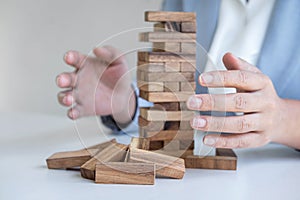 Alternative Risk and Strategy in business, Business woman`s hands protect balance wooden stack with hand control risk shape