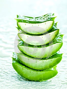 Alternative skin care aloe vera stack on white table with water