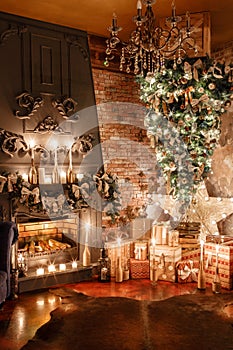 Alternative tree upside down on the ceiling. Winter home decor. Christmas in loft interior against brick wall.