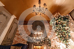 Alternative tree upside down on the ceiling. Winter home decor. Modern loft interior with fireplace and brick wall